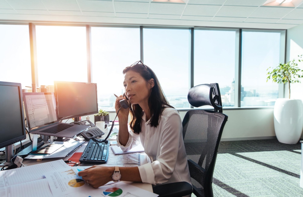woman using a business phone at work. Learn more about Digital Agent's business phones in our partner resources.